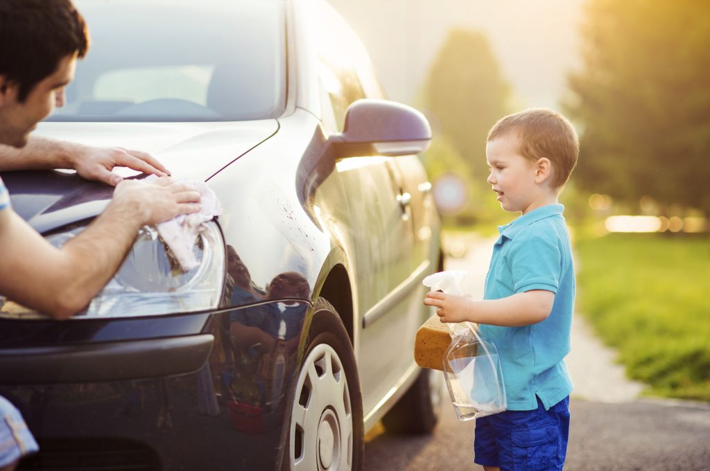 child standing beside vehicle