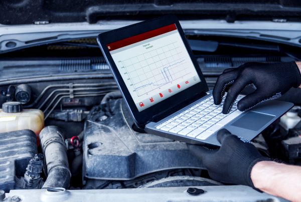 Repairman is conducting diagnostics and detecting problems at car repair shop